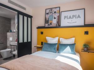 a bedroom with a large bed with a yellow headboard at Hôtel Piapia in Paris