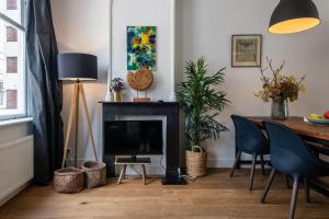 a living room with a fireplace and a table with chairs at Luxury & Style In Center Jordaan in Amsterdam