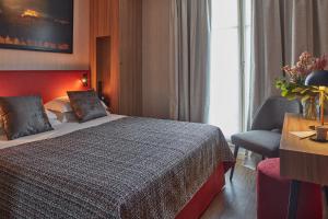 um quarto de hotel com uma cama e uma cadeira em Hotel Atmospheres em Paris