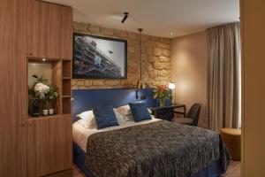 a bedroom with a bed and a painting on the wall at Hotel Atmospheres in Paris