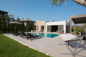 a patio with chairs and a swimming pool at Sweet Villas in Lygia