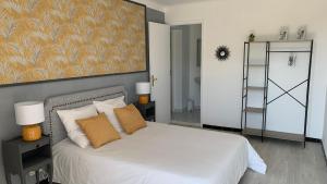 a bedroom with a bed with white sheets and orange pillows at Villa Maya in Lambesc