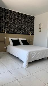 a bedroom with a large white bed with a black wall at Villa Maya in Lambesc