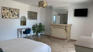 a white bedroom with a bed and a fireplace at Villa Maya in Lambesc