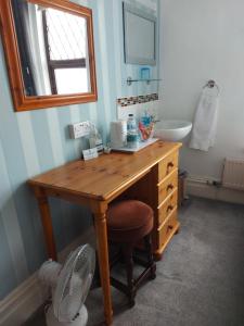 a bathroom with a wooden desk and a sink at Craigwell in Morecambe