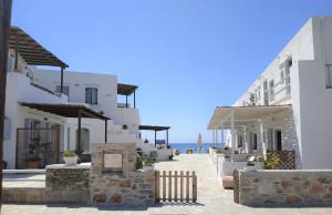 une rangée de bâtiments blancs avec l'océan en arrière-plan dans l'établissement Ammos Sifnos Village, à Platis Gialos