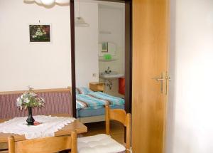 um quarto com uma mesa, uma cama e um espelho em Pension Weiss em Drobollach am Faakersee