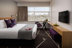 a hotel room with a bed and a flat screen tv at Rydges Campbelltown in Campbelltown