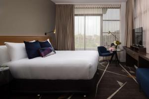 a hotel room with a large bed and a window at Rydges Campbelltown in Campbelltown