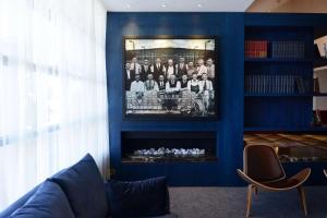 a living room with a blue wall with a fire place at Powerhouse Hotel Tamworth by Rydges in Tamworth