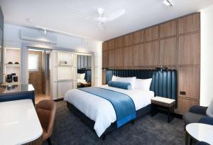 um quarto de hotel com uma cama, uma mesa e cadeiras em Powerhouse Hotel Tamworth by Rydges em Tamworth