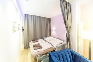 ein Krankenhauszimmer mit zwei Betten und einem blauen Stuhl in der Unterkunft Altstadt Studio Papenstraße in Stralsund