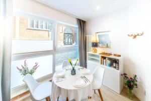 ein Esszimmer mit Tisch und Stühlen und einem Fenster in der Unterkunft Altstadt Studio Papenstraße in Stralsund