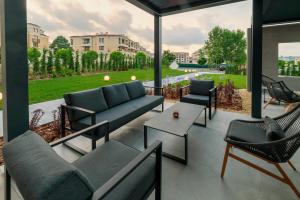 a patio with couches and chairs and a large window at Green Life Sozopol Antares in Sozopol