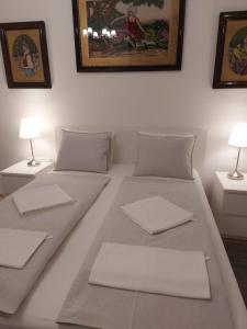 uma cama branca com duas mesas e duas lâmpadas em Melinda Apartman 2 em Budapeste