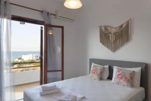 a bedroom with a white bed and a large window at Summer View in Skala