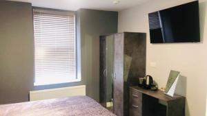 a bedroom with a bed and a television and a dresser at Market in Elsecar +37 photos