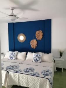 una camera da letto con una parete blu e 2 letti di La Buganvilla Beach House a Calahonda