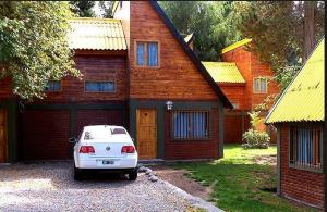 a white car parked in front of a house at Complejo Los Arrayanes in San Carlos de Bariloche