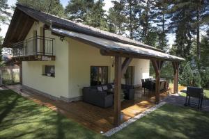 a house with a wooden deck with a roof at Chata Emily in Smižany