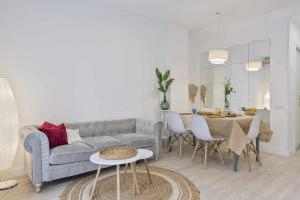 ein Wohnzimmer mit einem Sofa und einem Tisch in der Unterkunft Apartment Gaudi in Sitges