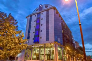希洪的住宿－Hotel Zentral Gijón Rey Pelayo，上面有蓝色的灯光的建筑