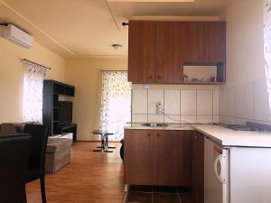 eine Küche mit Holzschränken und ein Wohnzimmer in der Unterkunft Apartman Sasa in Banja Koviljača