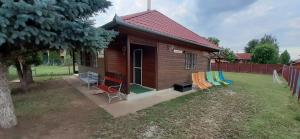 ベレクフェルドにあるVacsacsi vendégházの小さな木造家屋(中庭に椅子付)