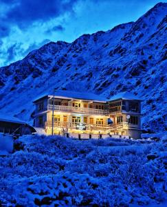 a building in the middle of a snow covered mountain at LAP Stays - Wanderer's Nest in Chitkal