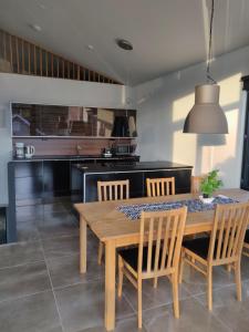 a kitchen with a wooden dining table and chairs at Villa Gardens in Imatra