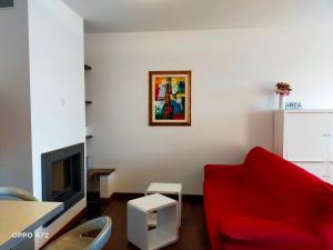 a living room with a red couch and a tv at L'OLIVO appartamento turistico in Lucignano