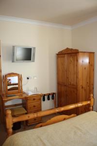 um quarto com uma cama, uma cómoda e um espelho em Dan O'Hara Farmhouse B&B em Clifden