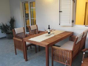 a wooden table with chairs and a bottle of wine at Apartment Klesinger in Poreč