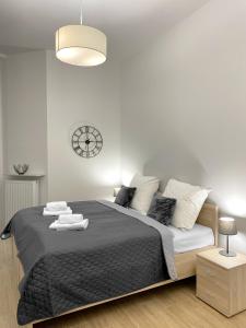 a bedroom with a large bed with a clock on the wall at Starowiślna 41-43 by PI Apartments in Kraków +46 photos