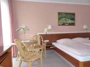 een hotelkamer met een bed en een tafel en stoelen bij Hotel Dorotheenhof in Cottbus
