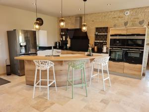 a kitchen with a large island with two bar stools at Chez Clément in Balesmes-sur-Marne