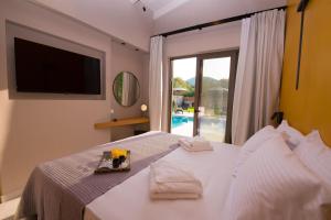 a bedroom with a bed with a tv and a window at Sweet Villas in Lygia +80 photos
