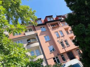 un edificio alto de color rosa con ventanas laterales en Powstańców 22' Street Apartamenty i Pokoje en Katowice