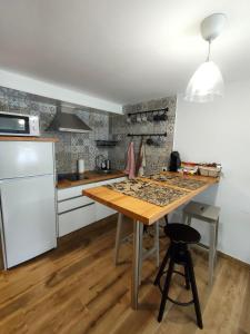 eine Küche mit einem Holztisch und einem weißen Kühlschrank in der Unterkunft Casa Luis in Arzúa