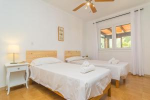 a bedroom with two beds and a ceiling fan at Can Clavell in Artá +26 photos