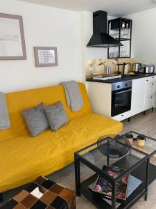 a yellow couch in a living room with a kitchen at city roof in Teterow
