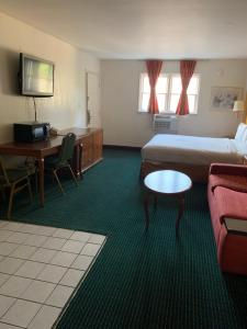 a hotel room with two beds and a desk at Americas Best Value Inn - Roxboro in Roxboro