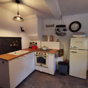 una cucina con piano cottura bianco e frigorifero di Lutzmannalm a Lassing