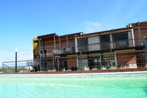 ein Gebäude mit einem Swimmingpool vor einem Gebäude in der Unterkunft Rahuen Hotel/Restaurant in Carpintería