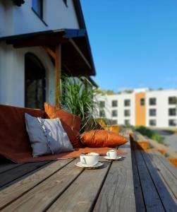 un sofá en una mesa de madera con 2 tazas de café en Hotel Odpocznia Resort i Las en Jaracz