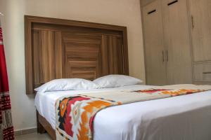 - une chambre avec un grand lit et une tête de lit en bois dans l'établissement Bonito y cómodo apartamento a tu alcance, à Cancún
