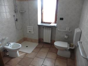 a bathroom with a toilet and a sink at Hotel Mont Nery in Challand Saint Anselme