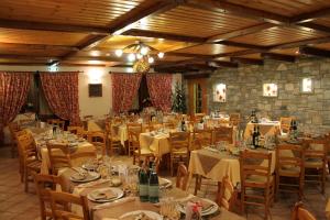 ein großes Esszimmer mit Tischen und Stühlen sowie Flaschen Wein in der Unterkunft Hotel Mont Nery in Challand Saint Anselme