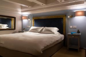 a bedroom with a large white bed and a mirror at The Xara Palace Relais & Chateaux in Mdina