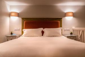 a bedroom with a large bed with two night stands at The Xara Palace Relais & Chateaux in Mdina